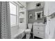 Bright bathroom featuring a tub with shower, built-in shelving, white vanity, and modern fixtures at 553 S Sherman St, Denver, CO 80209