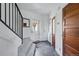 Bright and inviting foyer featuring classic wood doors, slate flooring, and a staircase with a black metal railing at 553 S Sherman St, Denver, CO 80209