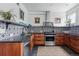 Stylish kitchen with stainless steel appliances, wood cabinets, black countertops, and patterned backsplash at 553 S Sherman St, Denver, CO 80209