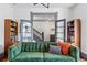 Comfortable living room featuring a decorative green sofa, hardwood floors, and unique bookcases at 553 S Sherman St, Denver, CO 80209