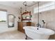 Elegant bathroom features a clawfoot tub, carved vanity, and travertine tile walls at 2146 Savage Rd, Elizabeth, CO 80107