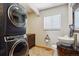 Convenient laundry area features stackable washer/dryer with an adjacent half bathroom at 2146 Savage Rd, Elizabeth, CO 80107