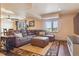 Spacious living room features a plush brown sectional sofa and stylish decor at 2146 Savage Rd, Elizabeth, CO 80107