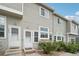 Exterior view of townhomes with white doors, gray siding, and minimal landscaping in front of the units at 8199 Welby Rd # 1903, Denver, CO 80229