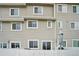 Exterior facade view showing windows, sliding doors and back patio area with closed umbrella at 8199 Welby Rd # 1903, Denver, CO 80229