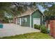 Exterior view of the green pool house building with white door, surrounded by concrete, grass and greenery at 8199 Welby Rd # 1903, Denver, CO 80229