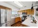 Well-equipped kitchen with stainless steel appliances, wood cabinets, and a view from the window at 8199 Welby Rd # 1903, Denver, CO 80229