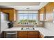 Bright kitchen with stainless steel sink, view from the window and wood cabinets at 8199 Welby Rd # 1903, Denver, CO 80229