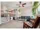 Open-concept living room with view of staircase, comfortable seating, and a ceiling fan at 8199 Welby Rd # 1903, Denver, CO 80229