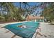 A covered community pool, with a covered green building in the background, surrounded by mature trees at 8199 Welby Rd # 1903, Denver, CO 80229