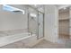 Bright bathroom featuring a soaking tub with marble tile surround and glass enclosed shower at 24563 E 34Th Ave, Aurora, CO 80019