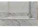 Close-up of a soaking tub with a marble tile surround and chrome faucet at 24563 E 34Th Ave, Aurora, CO 80019