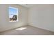 Empty bedroom bathed in sunlight through a window, showcasing neutral carpet at 24563 E 34Th Ave, Aurora, CO 80019