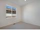 A well-lit bedroom has neutral carpet and a large window with a view of the community at 24563 E 34Th Ave, Aurora, CO 80019