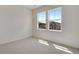 Sunlit empty bedroom with plush carpet and a view of neighboring homes through the windows at 24563 E 34Th Ave, Aurora, CO 80019