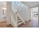 Bright foyer features a staircase with white railings, wood floors, and a view of the powder room at 24563 E 34Th Ave, Aurora, CO 80019