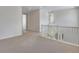 Hallway with white railing, large windows and neutral carpet, leading to other rooms at 24563 E 34Th Ave, Aurora, CO 80019