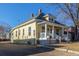 Exterior view of a charming yellow home with a covered front porch and gravel driveway at 219 Terry St, Longmont, CO 80501