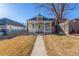 Inviting yellow home showcasing a cozy covered porch and manicured lawn for idyllic curb appeal at 219 Terry St, Longmont, CO 80501