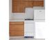 Compact kitchen featuring wooden cabinets, white appliances, and light countertops at 219 Terry St, Longmont, CO 80501
