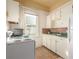 Cozy kitchen featuring white cabinets, appliances, and a window providing natural light at 219 Terry St, Longmont, CO 80501
