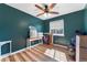 Cozy bedroom with a ceiling fan, natural light, and beautiful hardwood floors at 1086 Mockingbird St, Brighton, CO 80601