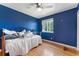 Charming bedroom featuring hardwood floors, ceiling fan, daybed, window and blue walls at 1086 Mockingbird St, Brighton, CO 80601