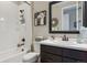 Well-lit bathroom with tile flooring, white tiled shower and tub, dark vanity, and updated fixtures at 3698 Penang Dr, Castle Rock, CO 80109
