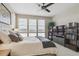 Bedroom with large window, comfortable bed, tv, bookshelves, and ceiling fan at 3698 Penang Dr, Castle Rock, CO 80109