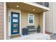 Inviting covered porch features a stylish blue door, seating, and manicured landscaping for a welcoming entrance at 3698 Penang Dr, Castle Rock, CO 80109