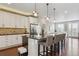 Modern kitchen features an island with seating, granite countertops, stainless appliances, and a brick backsplash at 3698 Penang Dr, Castle Rock, CO 80109
