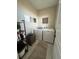 Efficient laundry room with a washer, dryer, storage shelving, and modern decor for convenience at 3698 Penang Dr, Castle Rock, CO 80109