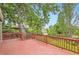 Relaxing back deck with a wooden railing, surrounded by lush trees and greenery at 1697 W Powers Ave, Littleton, CO 80120