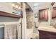 Bathroom featuring a tiled shower, wood cabinet, and granite sink at 1697 W Powers Ave, Littleton, CO 80120