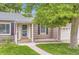 Charming home with a well-manicured lawn, complemented by trees and an inviting entryway with address number at 1697 W Powers Ave, Littleton, CO 80120