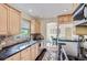 Cozy kitchen with wood cabinets, granite counters, stainless steel appliances, and an arched doorway to the dining room at 1697 W Powers Ave, Littleton, CO 80120