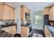 Well-lit kitchen featuring wooden cabinets, granite countertops, and stainless steel microwave at 1697 W Powers Ave, Littleton, CO 80120