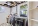 Well-lit laundry area with washer, dryer, shelving and backyard view at 1697 W Powers Ave, Littleton, CO 80120