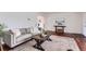 Living room with hardwood floors, a comfortable couch, an area rug, and natural light from the front window at 1697 W Powers Ave, Littleton, CO 80120