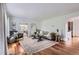 Inviting living room with hardwood floors, a comfortable couch, an area rug, and natural light from the sunroom at 1697 W Powers Ave, Littleton, CO 80120
