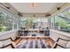 Bright sunroom with hardwood floors, built-in bookshelves, large windows overlooking the backyard, and stylish décor at 1697 W Powers Ave, Littleton, CO 80120