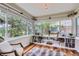 Bright sunroom with hardwood floors, built-in bookshelves, large windows overlooking the backyard, and stylish décor at 1697 W Powers Ave, Littleton, CO 80120