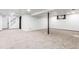 Finished basement with neutral carpet, white walls, and black support beam ready for customization at 8736 E Easter Ave, Centennial, CO 80112