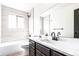 Bright bathroom with modern vanity, soaking tub, and tiled walls at 8736 E Easter Ave, Centennial, CO 80112