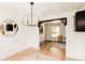 Dining room with modern chandelier, wood floors, and black trimmed archway to another room at 8736 E Easter Ave, Centennial, CO 80112
