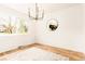 Bright dining room with wood floors, a modern chandelier, and a gold trimmed mirror at 8736 E Easter Ave, Centennial, CO 80112