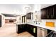 Stylish kitchen with white counters, dark cabinets, and stainless steel appliances adjacent to living room at 8736 E Easter Ave, Centennial, CO 80112