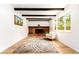 Living room featuring a brick fireplace, wood floors, beamed ceilings, and lots of natural light at 8736 E Easter Ave, Centennial, CO 80112