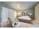 Spacious bedroom with double doors and a sitting chair at 6702 S Ivy Way # A1, Centennial, CO 80112