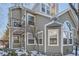 Two-story townhome with gray siding, balcony, and snowy landscaping at 6702 S Ivy Way # A1, Centennial, CO 80112